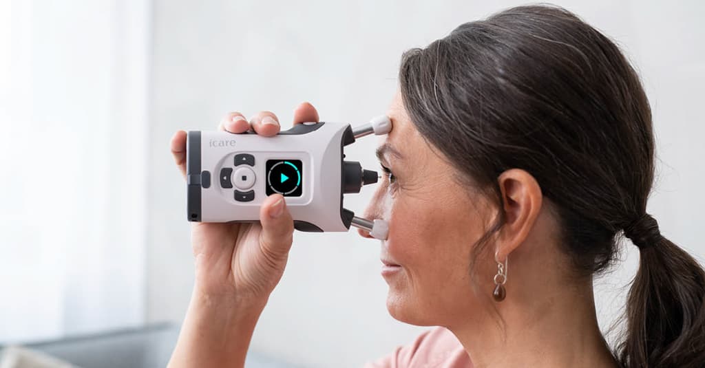 Patient using the iCare HOME2 at home for eye pressure monitoring